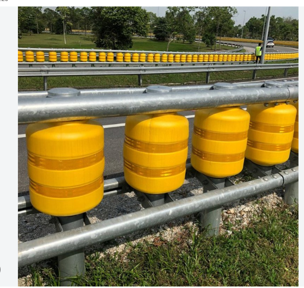 Continuous yellow rolling barrier installed beside a road